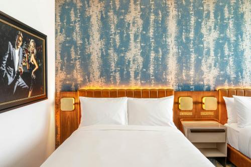 a bedroom with a bed and a painting on the wall at The REMI Scottsdale, Autograph Collection in Scottsdale