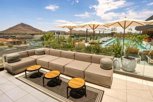 a patio with a couch and chairs and a pool at The REMI Scottsdale, Autograph Collection in Scottsdale