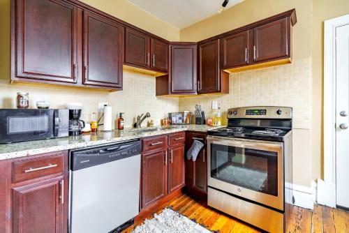 a kitchen with wooden cabinets and a stove top oven at Prime Location Top Rated Free Parking Clean in Columbus