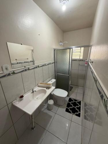 a white bathroom with a sink and a toilet at Hotel Germânico in Agudo