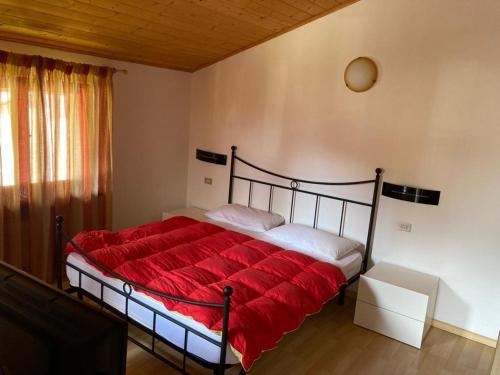 a bedroom with a bed with a red blanket at Appartamenti Elda Zandegiacomo in Auronzo di Cadore
