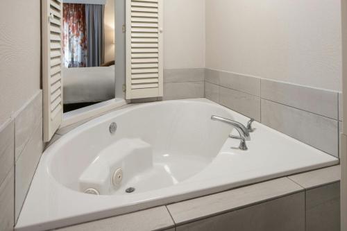 a white bath tub in a bathroom with a mirror at Fairfield by Marriott Ruston in Ruston