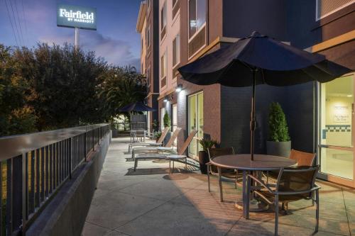 a table and chairs with an umbrella on a sidewalk at Fairfield by Marriott Ruston in Ruston