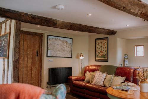 a living room with a brown leather couch at Slowley Farm in Luxborough