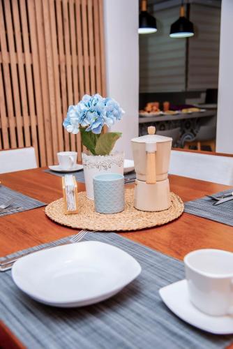 a table with plates and cups and a vase with flowers at Hogar de Olas Huanchaco in Huanchaco