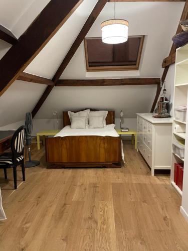 a bedroom with a bed and a desk in a attic at belle chambre moderne , avec douche équippement complet in Nogent-sur-Marne