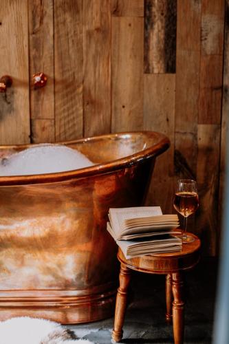 an old tub with a book and a glass of wine at Slowley Farm in Watchet
