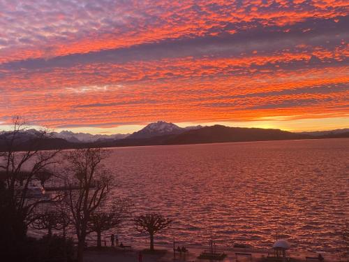 a sunset over a large body of water at Your home away from home in Zug in Zug