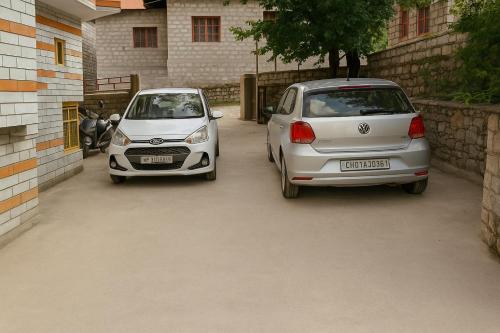 two white cars parked next to each other at Shree Ram Cottage, Manali - 1,2,3 Bedroom Luxury Cottages Available in Manāli