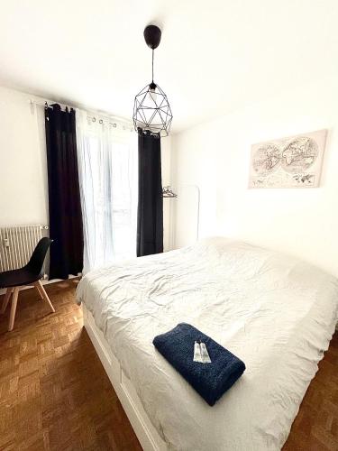 オルレアンにあるChambre Monde Tout confort Saint-Marceauの大きな白いベッドと青いタオルのある寝室