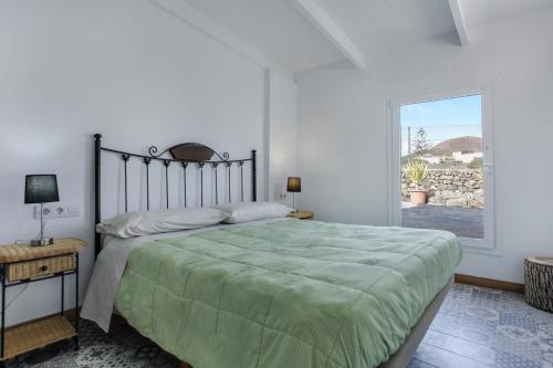 a bedroom with a large bed and a window at Villa Luna Wifi Fibra in Lajares