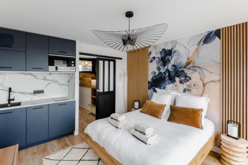 a bedroom with a white bed with towels on it at Horizon bleu depuis un studio unique in Carnac