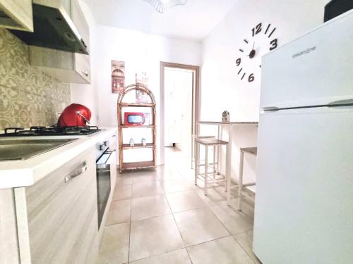 a kitchen with a white refrigerator and a counter at casa vacanza Terra del Primitivo in Manduria