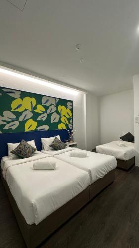 two beds in a bedroom with a large wall at Traveller Ark Hotel and Bunks in Kuala Lumpur