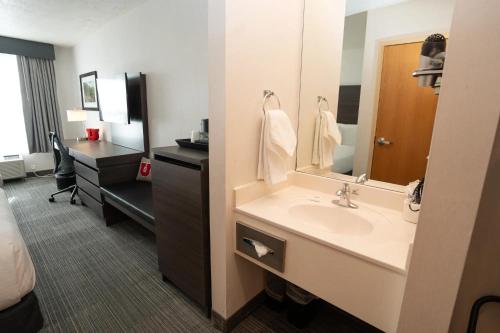 a bathroom with a sink and a mirror and a desk at University Guest House and Conference Center in Salt Lake City