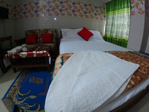 a bedroom with a bed and a chair and a bed sidx sidx sidx at Hotel Sadiq Residential in Dhaka