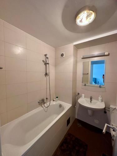 a white bathroom with a tub and a sink at Bellvil 55 in Belgrade