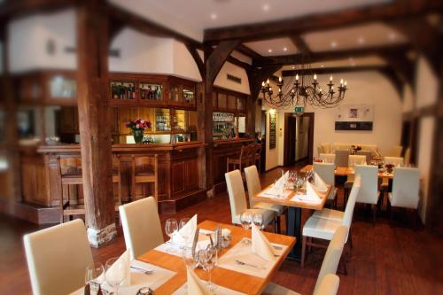 a dining room with wooden tables and white chairs at Hotel Marktkieker in Großburgwedel