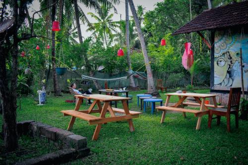 a group of picnic tables and chairs in a park at Munroe Paradise in Munroe Island