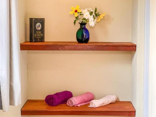 a shelf with three different colored pillows on it at Luamar Chalés in São Miguel do Gostoso