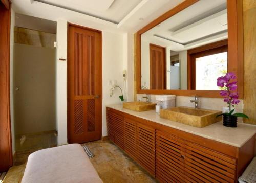 une salle de bain avec deux lavabos et un miroir dans l'établissement Villa in Cap Cana 4BR Green Village, à Punta Cana