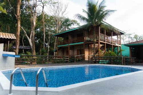 a resort with a pool in front of a building at Pousada Bellissima in Boicucanga