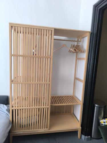 a wooden book shelf in a closet with shoes at Villa Leone Terminus in Dunkerque