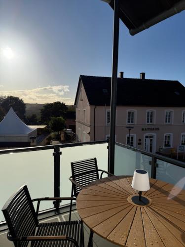 a wooden table and chairs on a balcony at Ferienwohnung Claudia in Clausen
