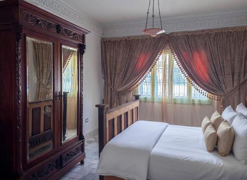 Un dormitorio con una cama grande y una ventana grande. en Dar El Nour Corniche Hammamet, en Hammamet
