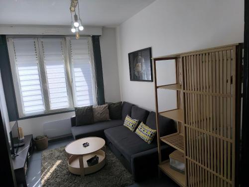 a living room with a couch and a table at Villa Leone Terminus in Dunkerque