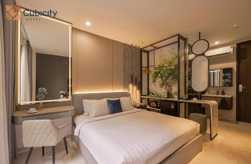a bedroom with a bed and a desk and a mirror at Cubicity Pho Duc Chinh in Ho Chi Minh City