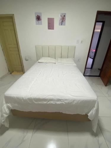 a large bed in a room with a white bedspread at Hostel da Dinda in São Luís