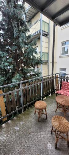 a patio with two chairs and a table and stool at Goethe Appartment in Plauen