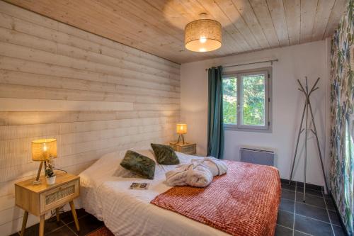 a bedroom with a bed and two lamps and a window at spa privatif intérieur du lodge -la truffe- le bois de la pause- in Saint-Cybranet