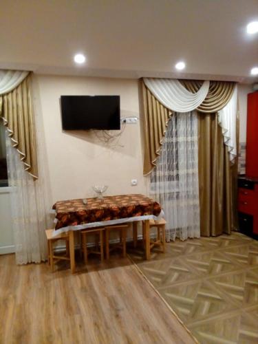 een woonkamer met een bank en een tv aan de muur bij Джермук in Dzjermoek