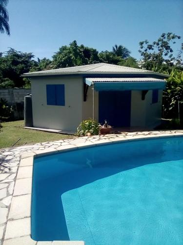 a house with a swimming pool in front of a house at Idéal pour séjour professionnel ou touristique in Baie-Mahault
