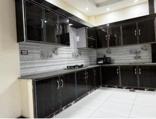 a kitchen with black cabinets and a white tile floor at Apartments 