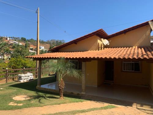 a house with a palm tree in front of it at Casa de Campo, no Paraiso, 3,5 KM da UFV e 6 KM do centro de Viçosa in Viçosa