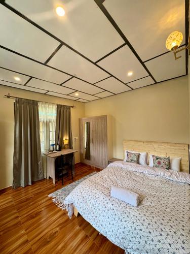 a bedroom with a large bed and a desk at Eevolve Dharamkot - An Eco Hostel in McLeod Ganj