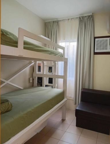 a bedroom with two bunk beds and a window at DaLei 3- 103 Sleeps 8pax at Marina Spatial Condominium in Dumaguete City in Dumaguete