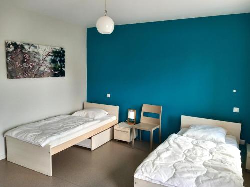 GuéreinsにあるLes Gites de la Calonneの青い壁の部屋にベッドが2つある