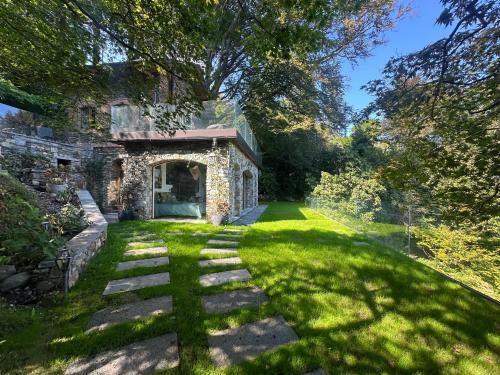 an old stone house with a grass yard at Private Luxury Spa & Silence Retreat with Spectacular View over the Lake Maggiore in Stresa