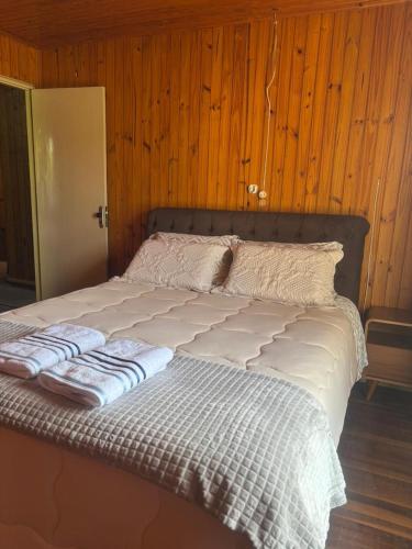 a bed with two pillows on it in a room at Casa Benedet's in Louro Müller
