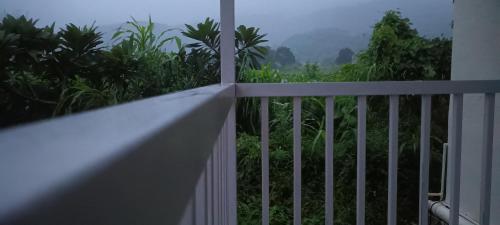 a white fence with a view of the jungle at The Crystal Villa in Karjat