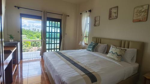 a bedroom with a large bed and a balcony at Koh Mook The Home in Ko Muk