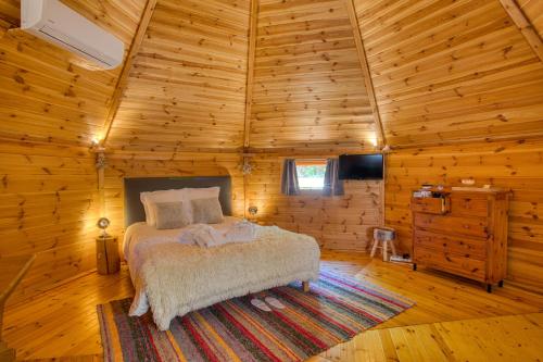 ein Schlafzimmer mit einem Bett in einer Holzhütte in der Unterkunft kota&bain nordique privatif-le bois de la pause- in Saint-Cybranet