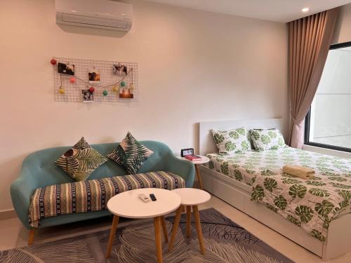 a small room with a bed and a couch at Vinhome Grand Park Homestay-HappyStay in Gò Công