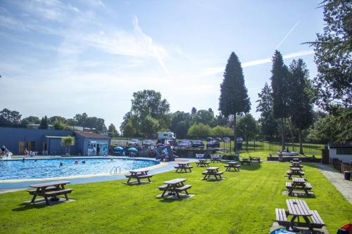 a picnic area with tables and a swimming pool at Relaxing static stay Holiday park in Northampton