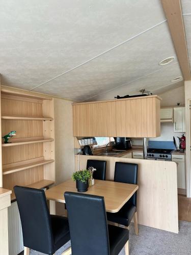a dining room with a wooden table and chairs at Relaxing static stay Holiday park in Northampton