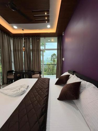 a bedroom with a large bed with a purple wall at Arvion Holidays in Vagamon